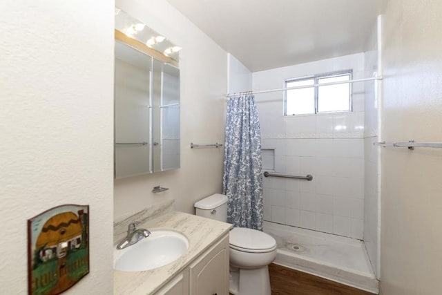 bathroom featuring vanity, wood-type flooring, toilet, and walk in shower