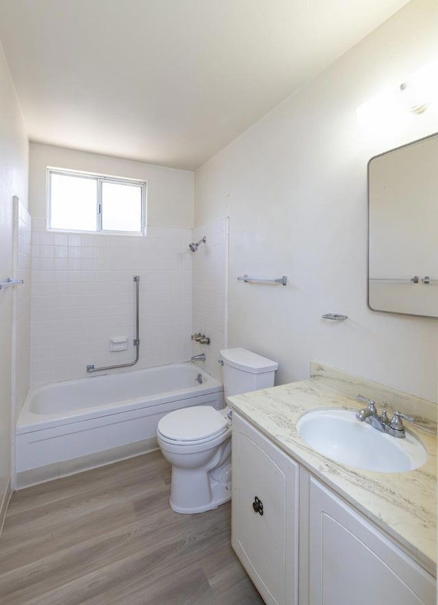 full bathroom featuring hardwood / wood-style flooring, vanity, toilet, and tiled shower / bath combo