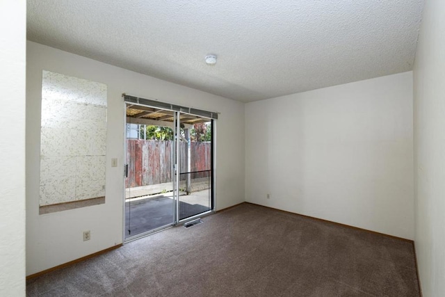 carpeted spare room featuring a textured ceiling