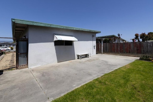 view of side of property with a yard and a patio