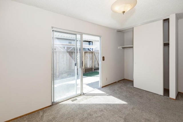 unfurnished bedroom with carpet floors, a closet, and a textured ceiling