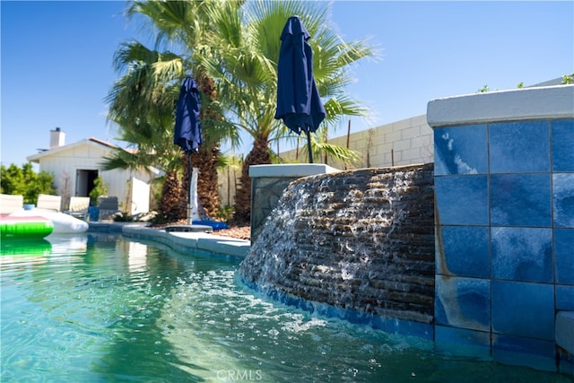 view of swimming pool with pool water feature