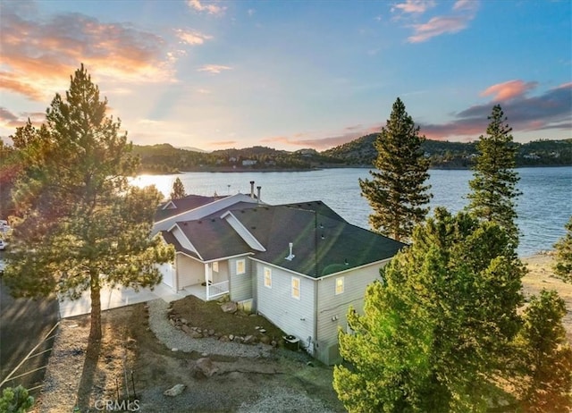 aerial view at dusk featuring a water view