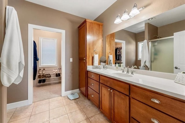 bathroom with tile patterned flooring, vanity, and walk in shower