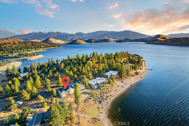 aerial view at dusk featuring a water and mountain view