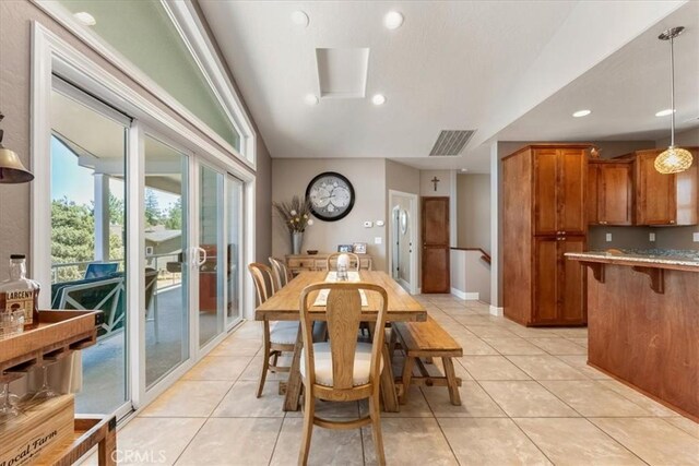 tiled dining room featuring vaulted ceiling