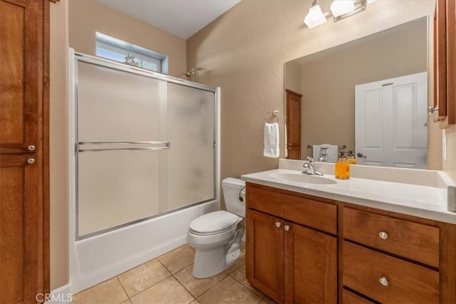 full bathroom featuring tile patterned flooring, vanity, enclosed tub / shower combo, and toilet