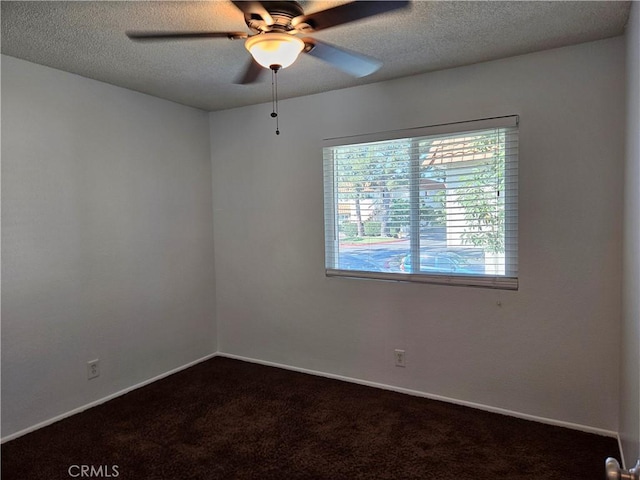 unfurnished room featuring a textured ceiling, dark colored carpet, and baseboards