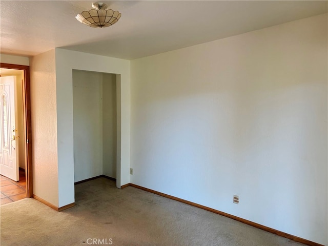 unfurnished bedroom with light carpet and a closet