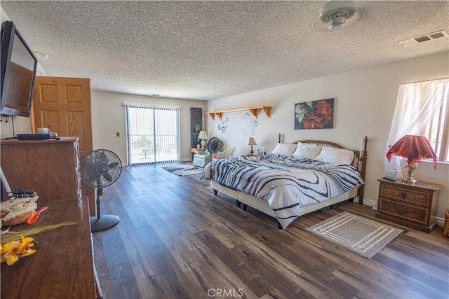 bedroom featuring dark hardwood / wood-style floors and a textured ceiling