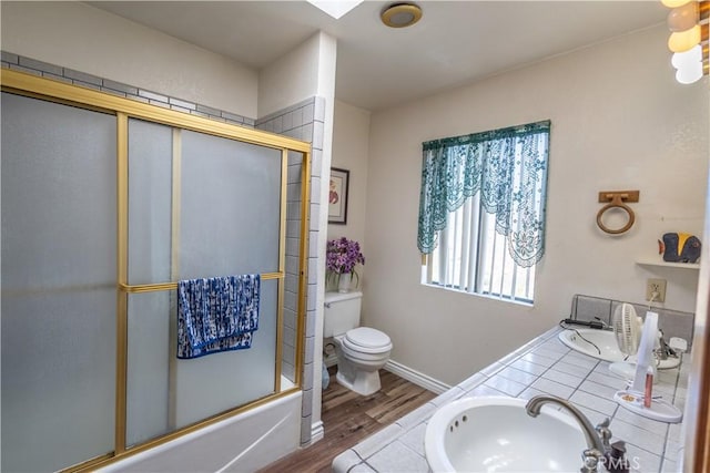 full bathroom with toilet, hardwood / wood-style flooring, vanity, and shower / bath combination with glass door