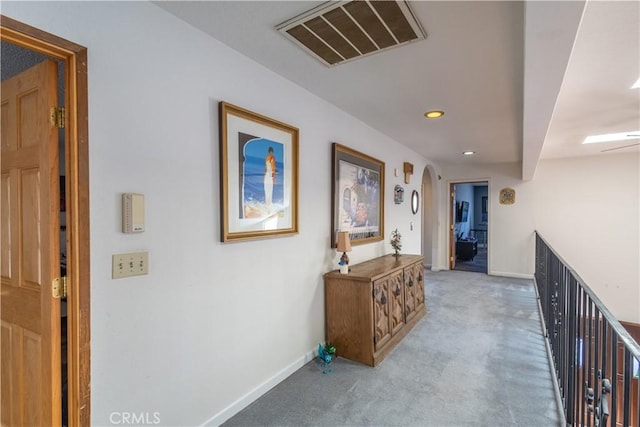 corridor featuring light colored carpet and beam ceiling