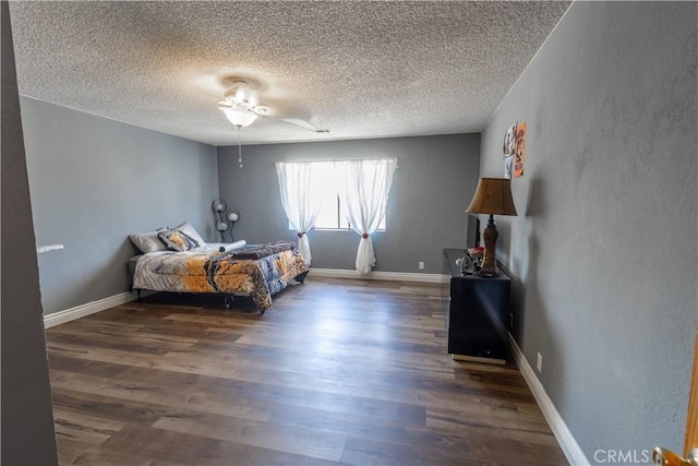 bedroom with ceiling fan, dark wood-type flooring, and a textured ceiling