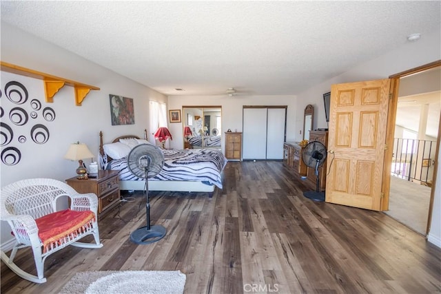 bedroom with a textured ceiling and dark hardwood / wood-style flooring