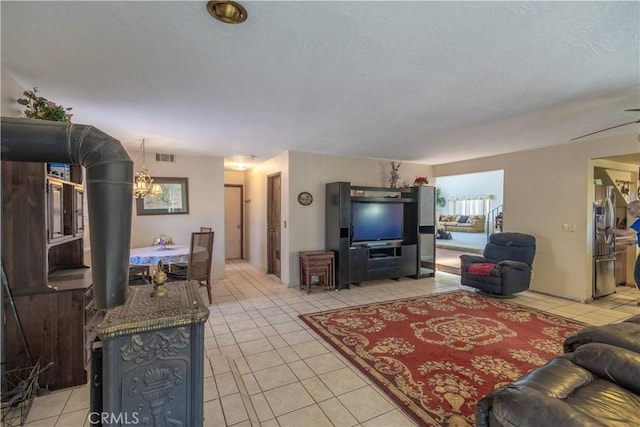 tiled living room featuring ceiling fan with notable chandelier