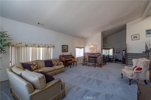 living room with lofted ceiling, ceiling fan, a brick fireplace, and carpet flooring