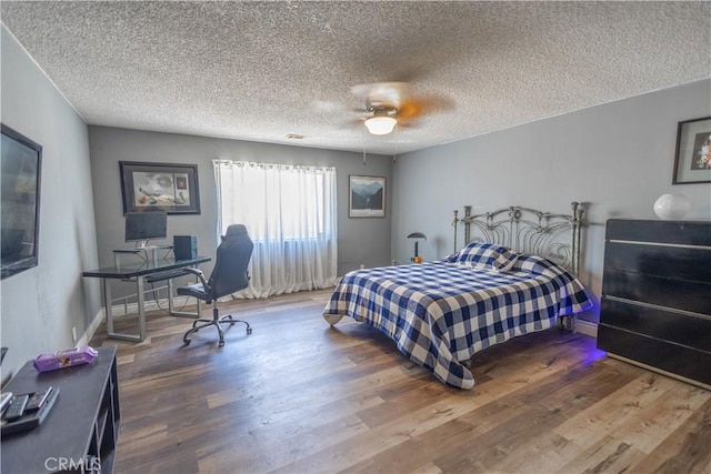 bedroom featuring a textured ceiling, ceiling fan, and hardwood / wood-style flooring