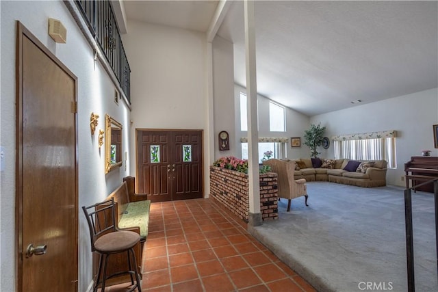 entryway featuring dark carpet and high vaulted ceiling