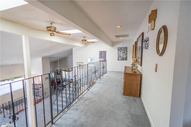 hall featuring carpet and vaulted ceiling with beams