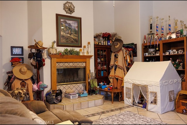 living room featuring a tile fireplace and light tile patterned floors