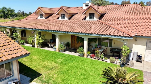 back of property with a yard and a patio area