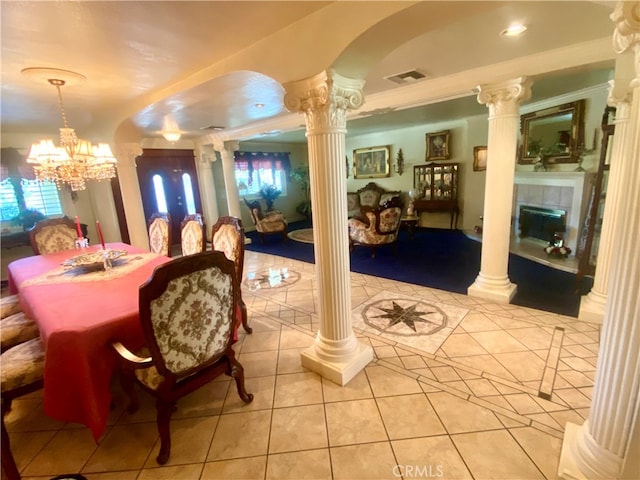 tiled dining room with decorative columns, an inviting chandelier, and crown molding