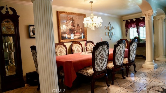 tiled dining area featuring ornate columns, ornamental molding, and an inviting chandelier