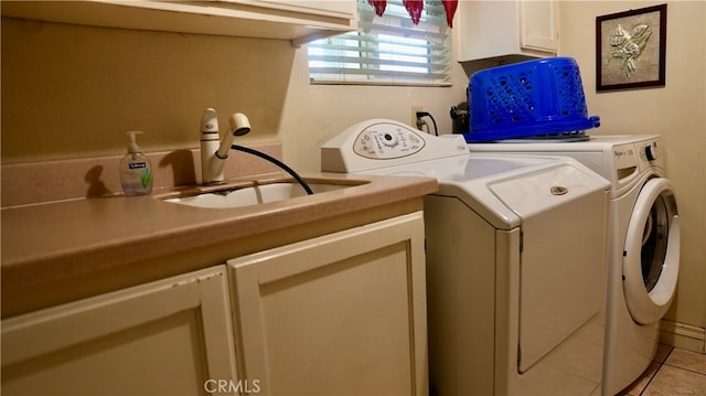 laundry area featuring washer and dryer, sink, light tile patterned floors, and cabinets