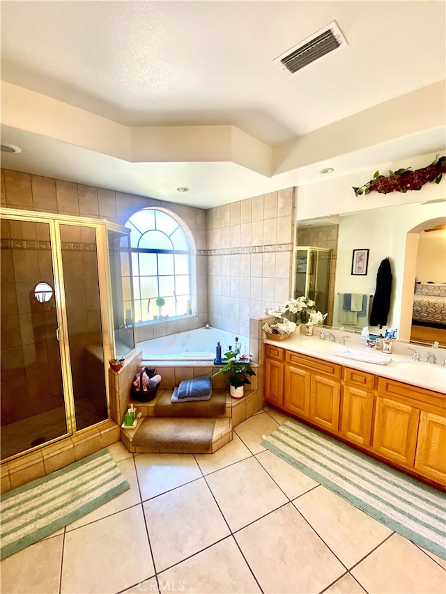 bathroom with tile patterned flooring, vanity, and shower with separate bathtub