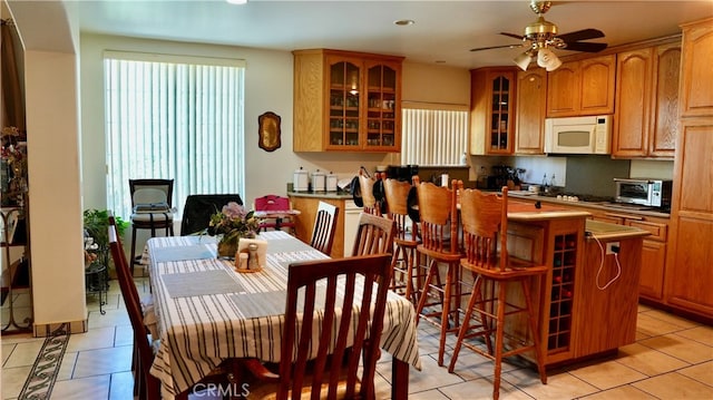 tiled dining space featuring ceiling fan