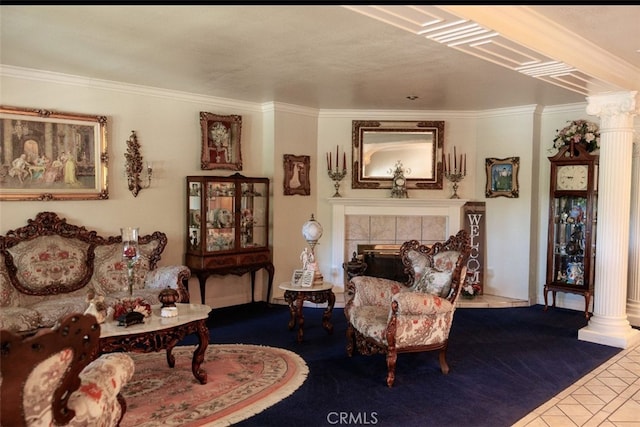 sitting room with a tile fireplace, decorative columns, tile patterned floors, and crown molding