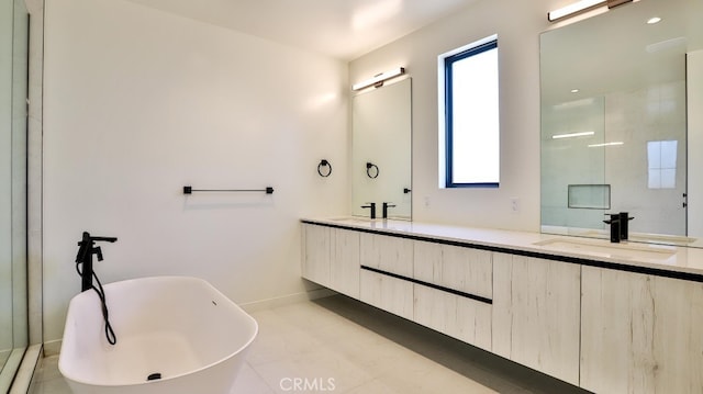 bathroom featuring tile patterned floors, vanity, a healthy amount of sunlight, and a tub