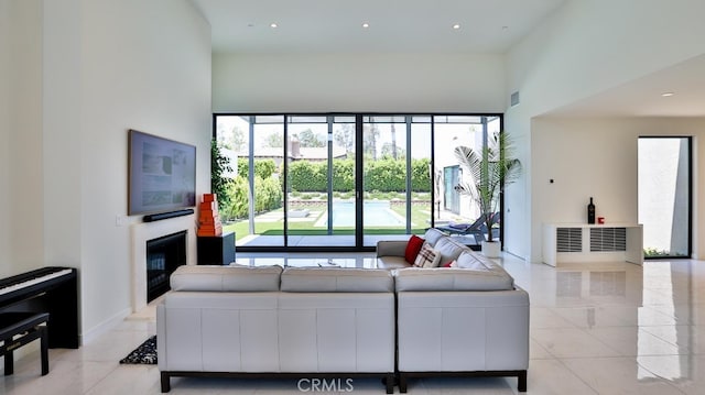 living room featuring light tile patterned flooring and a towering ceiling