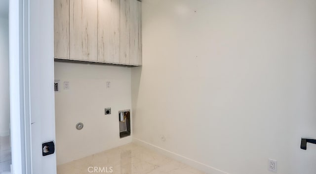 washroom with electric dryer hookup and cabinets