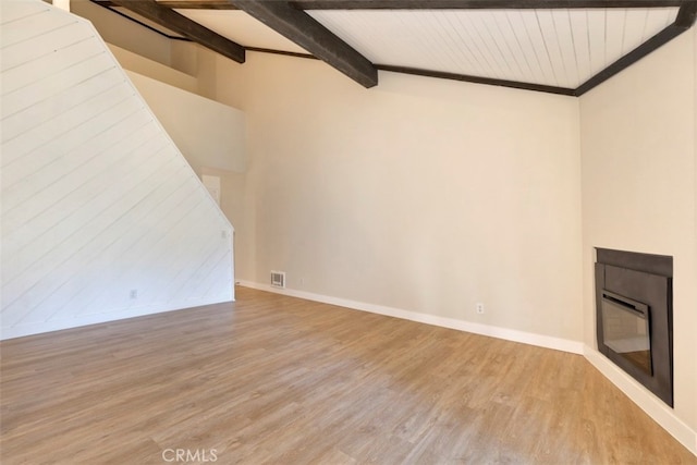 unfurnished living room with vaulted ceiling with beams and light hardwood / wood-style flooring