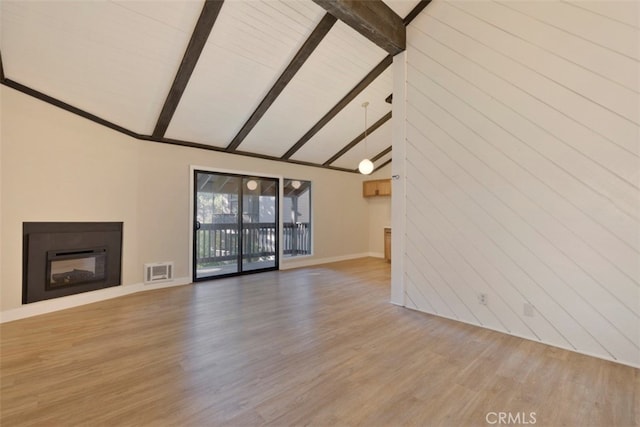 unfurnished living room featuring wood-type flooring, wood walls, beamed ceiling, and high vaulted ceiling