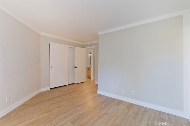 unfurnished bedroom featuring a closet, crown molding, and light hardwood / wood-style floors