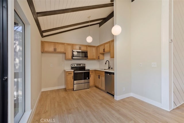 kitchen featuring lofted ceiling with beams, sink, hanging light fixtures, light hardwood / wood-style flooring, and appliances with stainless steel finishes