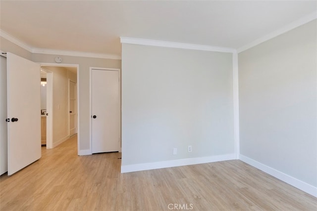 spare room featuring ornamental molding and light hardwood / wood-style floors