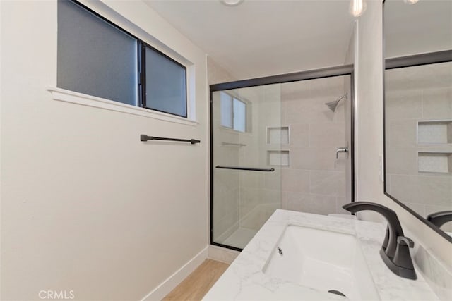 bathroom featuring a shower with door, hardwood / wood-style floors, and vanity