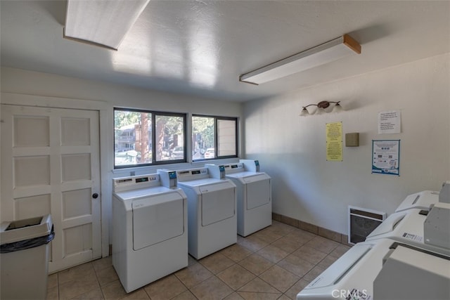 clothes washing area featuring light tile patterned floors and washer and dryer