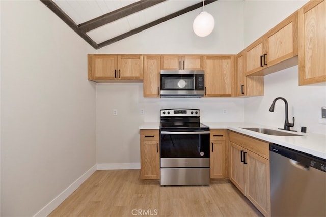 kitchen with pendant lighting, light hardwood / wood-style floors, sink, beam ceiling, and stainless steel appliances