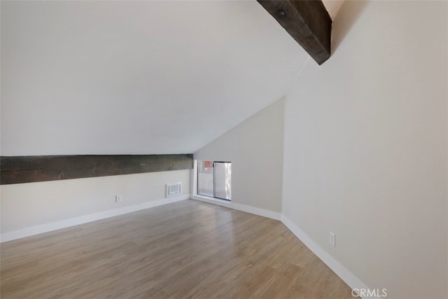 unfurnished living room with wood-type flooring and lofted ceiling with beams