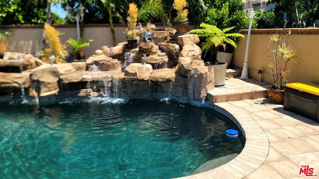 view of swimming pool with pool water feature