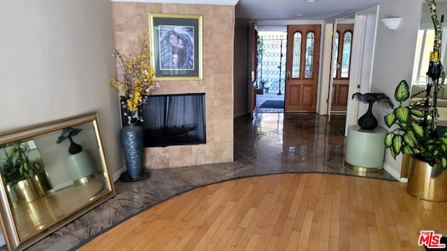 foyer entrance with dark hardwood / wood-style flooring and a high end fireplace