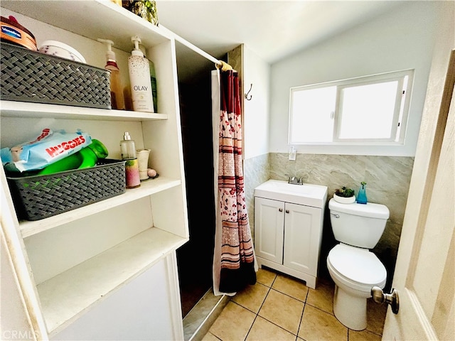 bathroom featuring a shower with curtain, tile patterned flooring, toilet, vanity, and tile walls