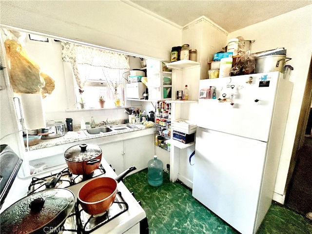 kitchen featuring white cabinetry, sink, white fridge, and a textured ceiling