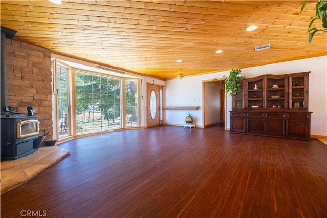 unfurnished living room with lofted ceiling, a wood stove, dark wood-type flooring, and wood ceiling