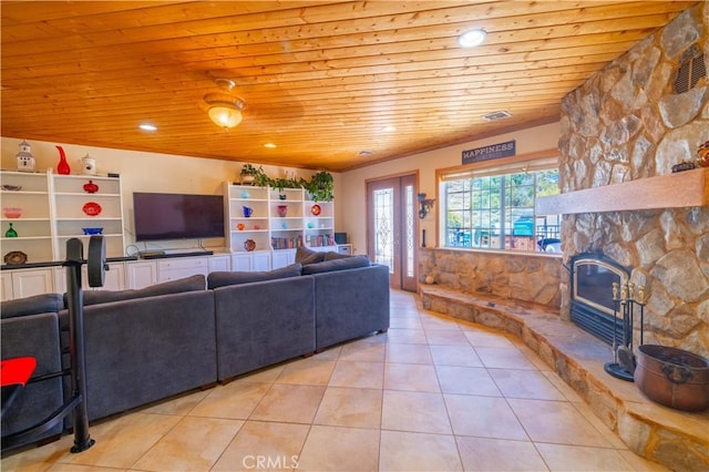 living room with light tile patterned floors, a stone fireplace, and wood ceiling