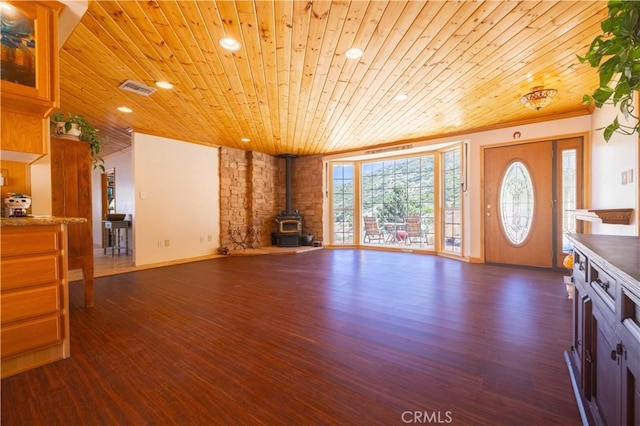 unfurnished living room with wooden ceiling, dark wood-type flooring, and a wood stove